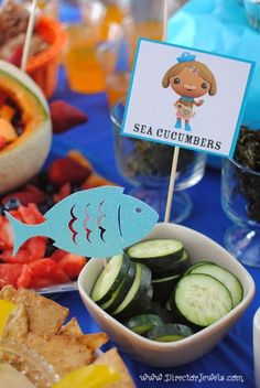 there is a bowl of cucumbers and other food on the table