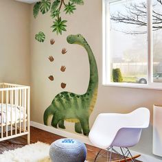 a baby's room with a dinosaur mural on the wall