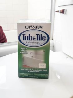 a box of tub and tile sitting on top of a white counter next to a sink