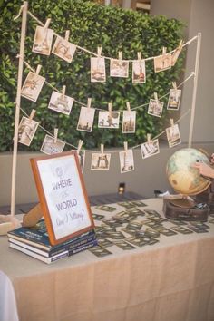 a table topped with books and pictures next to a sign that says where the world is