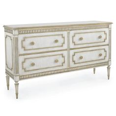 an antique white dresser with gold trimmings on the top and drawers, in front of