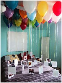 balloons are floating in the air over a table with pictures and photos on it's sides