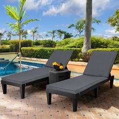 two lounge chairs next to a swimming pool