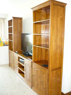 the entertainment center is made out of wood and has glass doors on both sides, along with built - in shelving units