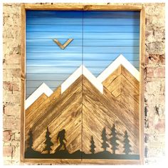 a wooden door with mountains and trees painted on it