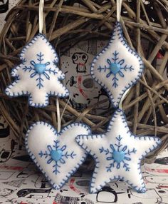 two blue and white snowflake ornaments hanging from a bird's nest