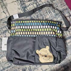 a winnie the pooh diaper bag is sitting on top of a carpeted floor