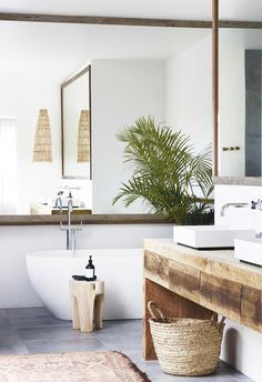 a bath room with a tub a sink and a mirror on the wall in front of it