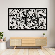 an abstract artwork hangs on the wall above a wooden sideboard in a living room