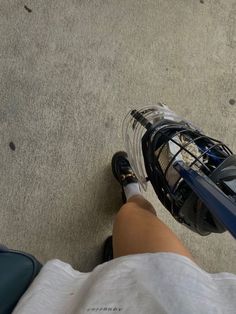 a person standing next to a blue and black electric scooter on the ground