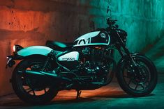 a black and white motorcycle parked in front of a wall with green lights on it