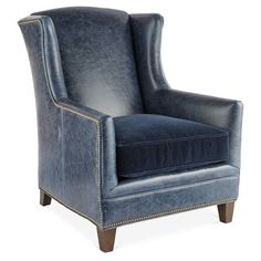 an upholstered blue chair with studding on the legs