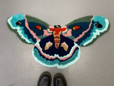 a butterfly shaped rug on the floor next to shoes