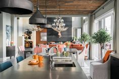 a kitchen and dining room with an island in front of the counter, chairs around it