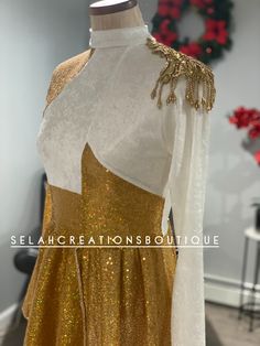 a gold and white dress is on display