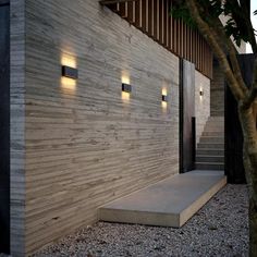 a modern house with stone steps leading up to the front door