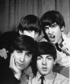 the beatles posing for a black and white photo