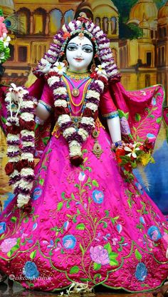 an idol is displayed in front of a wall with flowers and other decorations on it