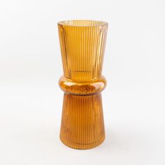 an orange glass vase sitting on top of a white table