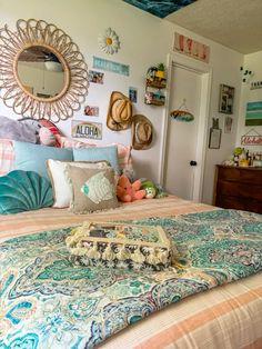 a bed room with a neatly made bed and lots of decorations on the wall above it