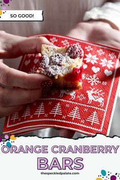 orange cranberry bars with powdered sugar on top are being held up by two hands