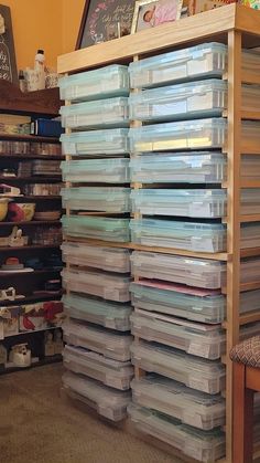 a large stack of plastic containers sitting on top of a wooden shelf