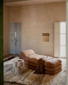 a living room with a couch and rugs on the floor in front of a door