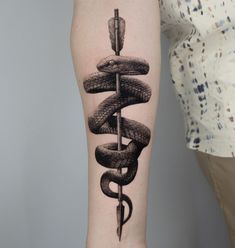 a snake and dagger tattoo on the arm