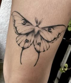 a small butterfly tattoo on the right side of the leg, it is black and white