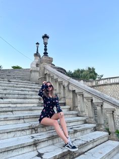 a woman sitting on some steps with her legs crossed