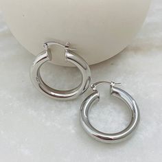 Introducing our classy chunky hoop earrings in thick silver: a harmonious blend of contemporary design and timeless elegance. These earrings redefine sophistication with their bold presence and refined craftsmanship, making them an essential addition to your jewelry collection. Crafted with meticulous attention to detail, these chunky silver hoop earrings offer a modern twist on a classic look. The earrings feature a substantial thickness that exudes confidence and style, while their polished silver finish catches and reflects light, creating a captivating play of sparkle. PRODUCT DESCRIPTION Item Description Thick Hoops Material: Rhodium Plated  -Size: 33 mm -Width: 5mm     BENEFITS -Hypoallergenic -Water Resistant -Tarnish Resistant -Perfect for all time. -High-quality Hoops! JEWELRY CAR Cheap Silver Tarnish Resistant Earrings, Silver Hoop Earrings Medium, Chunky Silver Earrings, Silver Hoops Earrings, Hoop Earrings Medium, Classy Earrings, Medium Hoop Earrings, Chunky Hoop Earrings, Hoops Earrings