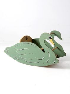 a green wooden toy boat with a swan on it