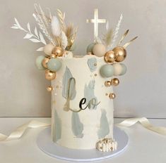 a white cake with gold decorations and a cross on the top that says eo