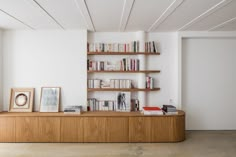 a bookshelf filled with lots of books next to a window