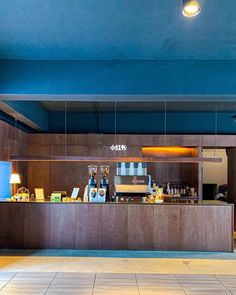 the inside of a restaurant with blue walls and wooden counter tops, along with tiled flooring