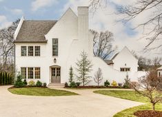 a large white house sitting on top of a lush green field