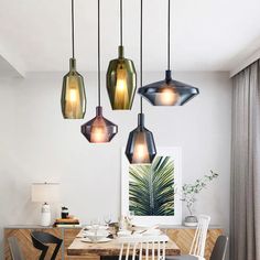 a dining room table with chairs and lights hanging from the ceiling