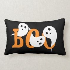 a black and white pillow with two ghost heads on it's side, which says boo