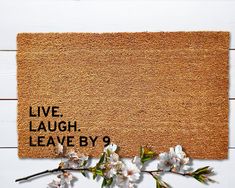 a door mat with the words live laugh leave by 9 on it next to flowers