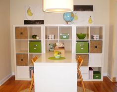 a white table with some green bins on it and a lamp hanging over it