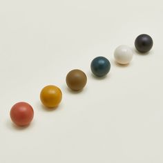 four different colored balls lined up in a row