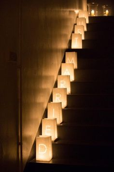 lighted paper bags are lined up on the stairs to be used as candles for an event