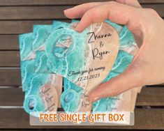 a hand holding a heart shaped card with the words free single gift box on it