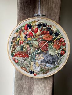 the embroidery is hanging on the wall by the window sill, and there are many different things in it