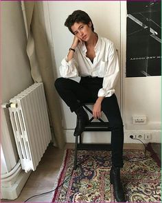 a man sitting on top of a chair next to a radiator