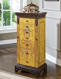 a tall yellow cabinet sitting on top of a hard wood floor next to a potted plant