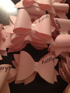 many pink bows with name tags attached to them