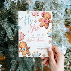 someone holding up a baby shower card in front of a christmas tree