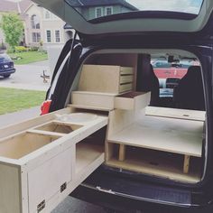 the back end of a van with its doors open and shelves in the cargo area