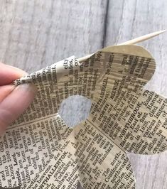 someone is making a paper flower out of newspaper